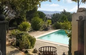 een zwembad in een tuin met een tafel en stoelen bij Awesome Home In Rochefort-du-gard With Kitchen in Rochefort-du-Gard