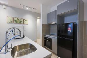 a kitchen with a sink and a black refrigerator at 10 min to My town family unit By Nexx Field in Kuala Lumpur