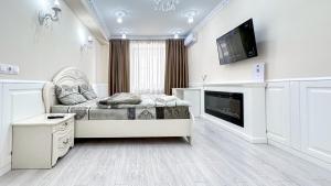 a white living room with a couch and a tv at Luxury Ismail Street in Chisinau in Chişinău