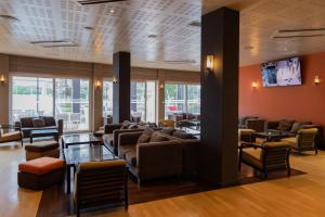 a lobby with couches and chairs and a tv at MS Aparthotel in Linda-a-Velha