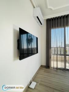 a living room with a flat screen tv on the wall at Dormir del Mar in La Marina