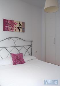 1 dormitorio con cama blanca y almohada rosa en VILLA BERMEJA 1 by Villitas, en Playa Blanca