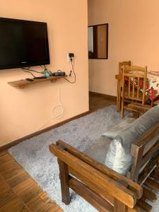 sala de estar con sofá y TV de pantalla plana en Pousada Brum en Pelotas