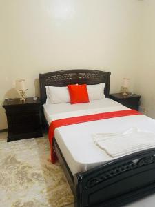a bedroom with two twin beds with red pillows at EliteOysterbay - 2 Bedroom Apartment in Dar es Salaam