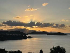 a sunset over a body of water with mountains at Villa Athena Skiathos in Megali Ammos