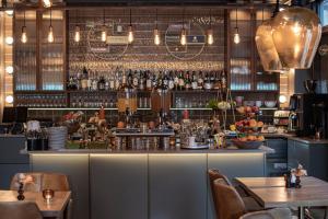 un ristorante con un bar con tavoli e sedie di V Hotel Helsingborg; BW Premier Collection a Helsingborg