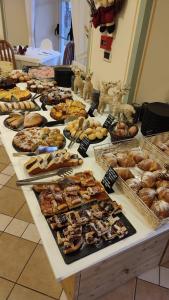 una tavola piena di diversi tipi di prodotti da forno di Hotel Europa a Molveno
