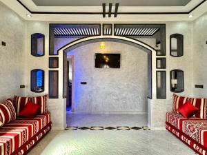 a living room with two red chairs and a door at Merzouga DesertView Apartment in Merzouga