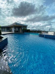 a large pool of blue water in front of a building at I chill Six Room in Ban Bang Saen (1)