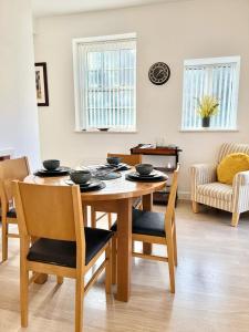 uma sala de jantar com uma mesa de madeira e cadeiras em Detached Pet Friendly Cottage, 2 parking spaces em Norwich