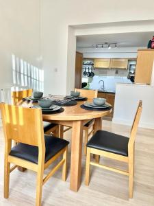 a wooden table and chairs in a kitchen at Detached Pet Friendly Cottage, 2 parking spaces in Norwich