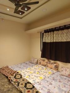 een slaapkamer met een bed met een dekbed erop bij SHRISHAILAM FARM AND YATRI NIWAS in Akalkot