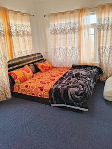 Bett in einem Zimmer mit Vorhängen in der Unterkunft MAGRAY GUEST HOUSE in Tangmarg