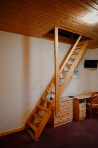 escalera de madera en una habitación con mesa en U dvou studní, en Loučná nad Desnou