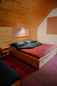 a bedroom with a bed in a wooden room at U dvou studní in Loučná nad Desnou