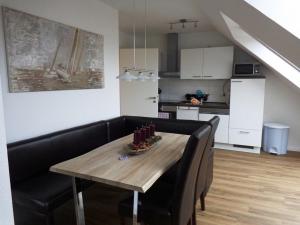 einen Esstisch mit schwarzen Stühlen und eine Küche in der Unterkunft Seaside - ABC415 in Wismar