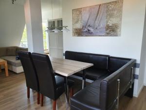 ein Esszimmer mit einem Holztisch und schwarzen Stühlen in der Unterkunft Seaside - ABC415 in Wismar