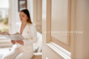 a woman in a white suit looking in a mirror at Al centro Luxury Home in Caserta