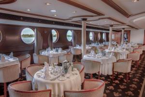 a dining car on a train with tables and chairs at Jaz Celebrity Nile Cruise - Every Saturday from Luxor for 07 & 04 Nights - Every Wednesday From Aswan for 03 Nights in Luxor