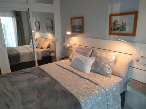 ein Schlafzimmer mit einem großen Bett und einem Spiegel in der Unterkunft 1 Bedroom Apartment in Pueblo Evita in Arroyo de la Miel