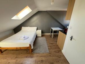 Private Studio Room With Your Shower and Kitchen في لندن: غرفة نوم صغيرة مع سرير في العلية