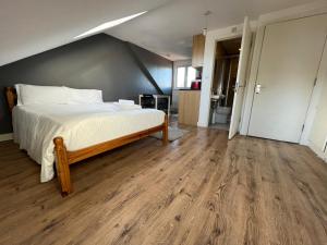 um quarto com uma cama grande e piso em madeira em Private Studio Room With Your Shower and Kitchen em Londres