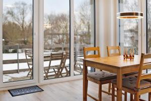 a dining room with a table and chairs and windows at Ferienwohnung Leineufer in Friedland