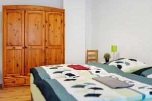 1 dormitorio con 2 camas y armario de madera en Ferienwohnung Leineufer en Friedland