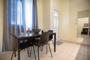 アテネにあるNeos kosmos 1 bedrm semi-basement flat by MPSの部屋のダイニングテーブルと椅子