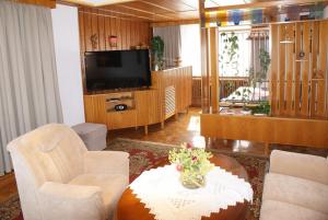 ein Wohnzimmer mit einem TV, Stühlen und einem Tisch in der Unterkunft Schöne Aussicht am Strand - ABC304 in Wismar