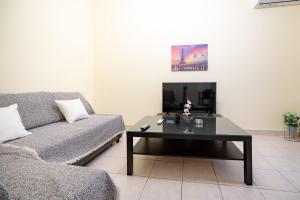 アテネにあるNeos kosmos 1 bedrm semi-basement flat by MPSのソファとコーヒーテーブルのあるリビングルーム