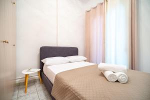 アテネにあるNeos kosmos 1 bedrm semi-basement flat by MPSのベッドルーム1室(ベッド2台、白いシーツ、タオル付)