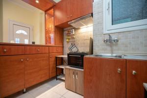 アテネにあるNeos kosmos 1 bedrm semi-basement flat by MPSの木製のキャビネットとシンクを備えたキッチン +13枚の写真