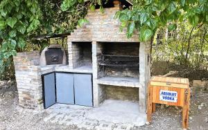 an outdoor brick oven with a grill and a stove at Casa con PILETA al borde del RIO in Benavídez