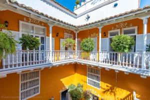 an orange building with white balconies and potted plants at Casa Ámbar Cavelier in Cartagena de Indias