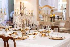 a table with gold and white plates and glasses at Casa Ámbar Cavelier in Cartagena de Indias