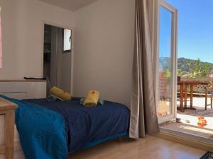 a bedroom with a blue bed and a sliding glass door at La terrasse des capucines in Sète