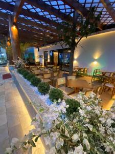 eine Terrasse mit Tischen, Stühlen und Blumen in der Unterkunft Pumma Business Hotel in Canaã dos Carajás