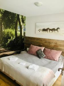 um quarto com uma cama grande com dois cavalos na parede em Borovets Gardens B21 Morunov Apart em Borovets