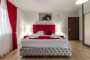 - une chambre avec un grand lit et une tête de lit rouge dans l'établissement Villa Yazır, à Antalya