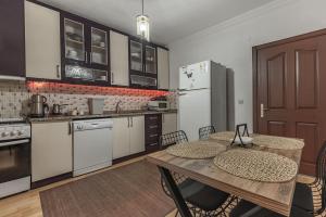 a kitchen with white appliances and a wooden table at Villa Yazır in Antalya +16 photos