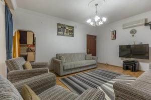 Il comprend un salon avec des canapés et une télévision à écran plat. dans l'établissement Villa Yazır, à Antalya