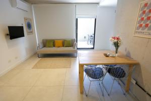 sala de estar con mesa y sofá en OWN Belgrano Studios & Suites en Buenos Aires
