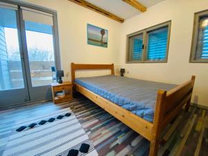 a bedroom with a bed in a room with windows at Panna Cottage in Badacsonytomaj