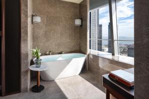 a bathroom with a tub and a window at Four Seasons Hotel Dalian in Dalian