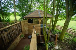 a wooden gazebo with a hot tub on a deck at Tree House in Thirsk