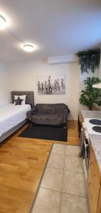 a living room with a bed and a kitchen at Studio apartment near metro and forest! in Stockholm