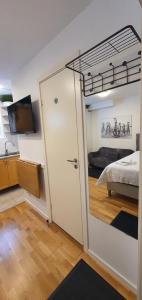 Studio apartment near metro and forest! في ستوكهولم: غرفة بسرير وباب يؤدي لغرفة النوم