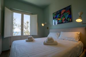 um quarto com uma grande cama branca com toalhas em Sunset View by Firenze Prestige em Quercianella