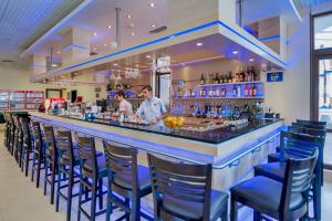 Um bar com um homem e uma mulher atrás dele. em Hermes Club Hotel - Ultra All Inclusive em Carevo